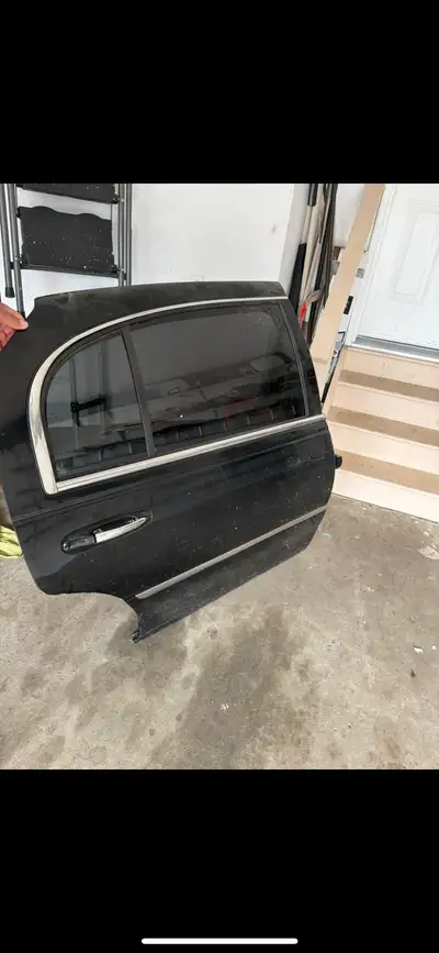 Black rear right door for Lincoln Town Car L series. Has wood trim on the inside and a silver handle...