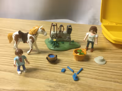 Cet ensemble Playmobil comprend deux figurines (adulte et enfant), un poney et divers accessoires po...