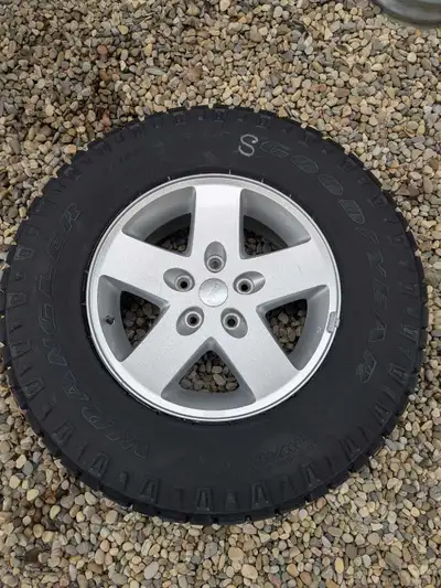 This set of 5 Goodyear Wrangler tires, size 255/75R17, are mounted on factory Jeep alloy wheels and...