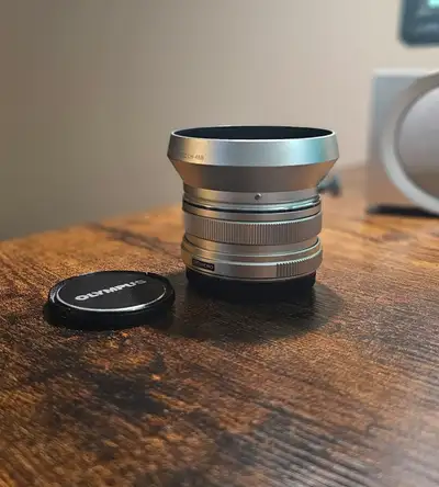 Lens is perfect, no marks or scratches anywhere. Includes box, lens hood, caps.