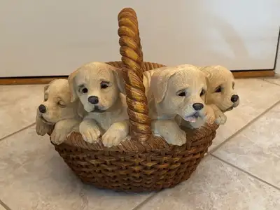 A ceramic-like decorative basket with four adorable golden retriever puppies.