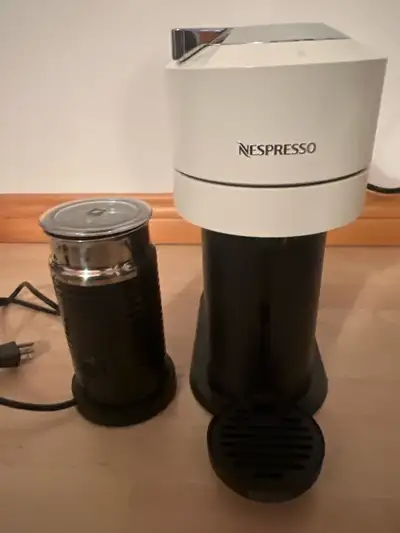 machine à café Nespresso Vertuo accompagnée de son mousseur à lait Aeroccino. Cet ensemble est en ex...