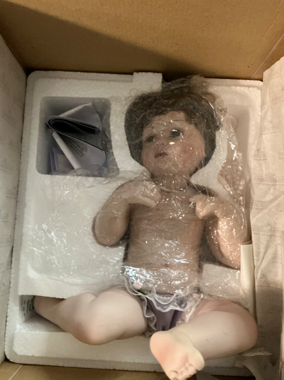 Porcelain doll with mirror it sits on. Displayed only and put back into original packaging. Comes wi...