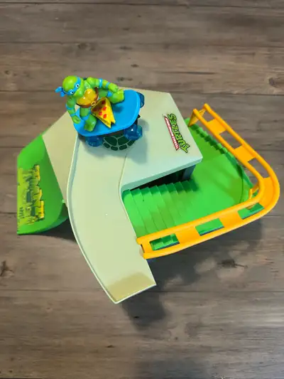 Small skateboard ramp kids play toy. Comes in pieces and easily pops together. Leonardo is attached...