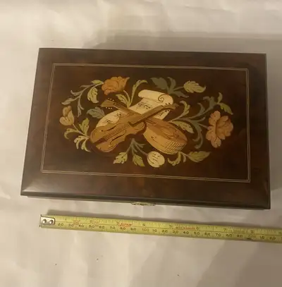 This vintage burl wood inlaid musical box is a beautiful and functional piece, playing the classic t...