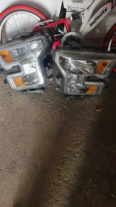 These are a pair of headlights removed from a 2015-2017 Ford F-150. They are in used condition, with...