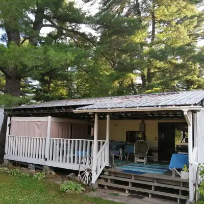 Wood deck with metal roof, currently covering a trailer, designed and built by previous owner, very...
