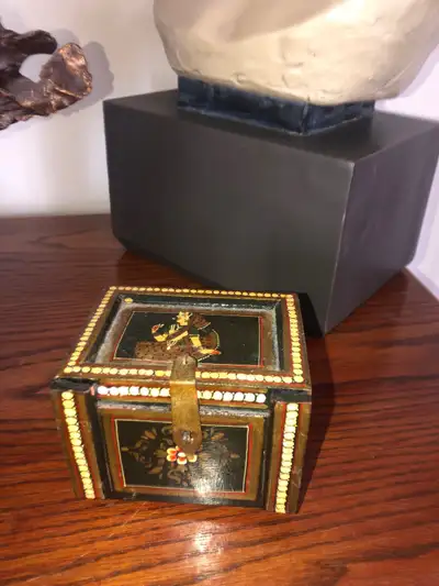 This charming, pre-owned hand-painted decorative jewelry box features intricate traditional artwork...