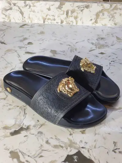 Stunning pair of Versace La Medusa Rubber Sliders in Black with Gold-tone accents. These luxurious p...