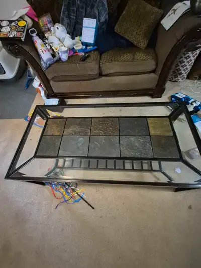 This glass and tile coffee table is a functional piece, perfect for any living room. It has some wea...