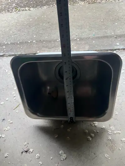 This is a used stainless steel sink, perfect for a small space or utility area, measuring approximat...