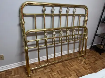 Victorian brass bed frame, including a headboard and footboard, featuring decorative ceramic knobs.