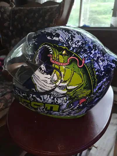Ce casque Icon Airmada est en état usagé, arborant un design graphique audacieux avec un motif de po...
