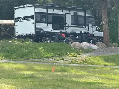 This toy hauler is versatile. It has a king size bed in the slide out, a drop down queen convertible...