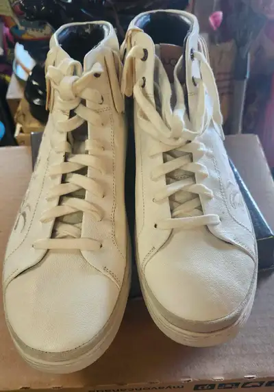 Step out in style with these UGG White Leather High Top Sneakers, featuring a fashionable fringe and...