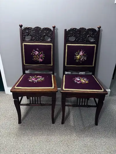 Beautiful pair of vintage chairs with intricate dark wood carvings and deep purple upholstery. Each...