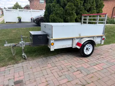 This sturdy pre-owned utility trailer features a reliable steel frame, a convenient rear ramp gate f...