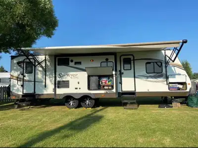 Spacious travel trailer has double-over-double bunk beds and a private master bedroom with a queen b...