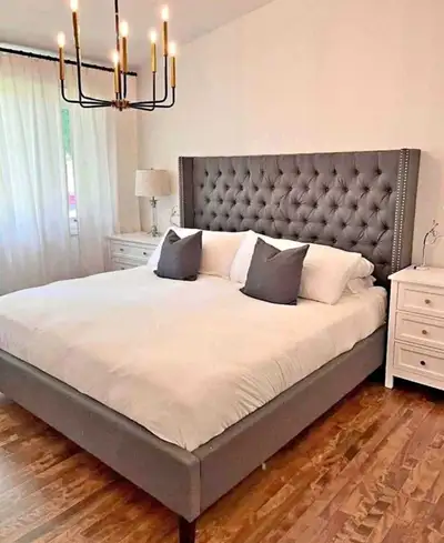 Create a serene and stylish bedroom with this beautiful upholstered bed frame, featuring a tufted he...