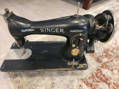 This iconic Singer sewing machine, a classic piece of functional history. This vintage model, with i...