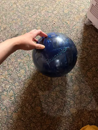 This is a used Brunswick bowling ball with a 'Wild Ride' graphic, perfect for enthusiasts looking fo...