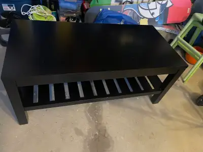 This is a black Ikea Lack coffee table that provides a sleek and functional addition to any living s...