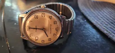 This pre-owned vintage Timex Quartz watch features a classic round face with easy-to-read numbers an...