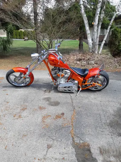 This custom-built chopper motorcycle features a striking orange flame paint job and is in good condi...