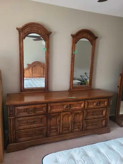 This vintage dresser and armoire wardrobe set features solid wood construction and ornate detailing,...
