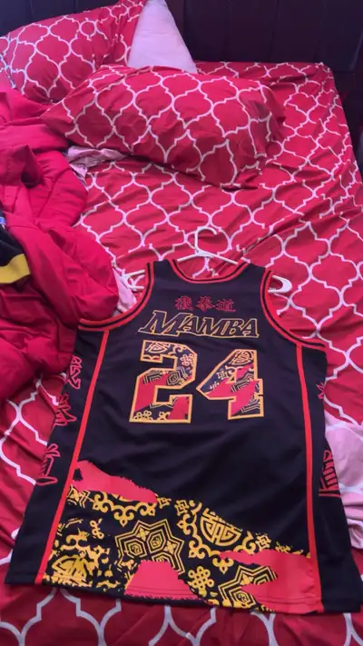 Men's black basketball jersey. Features number 24 and Los Angeles lettering. Red and gold Chinese-in...