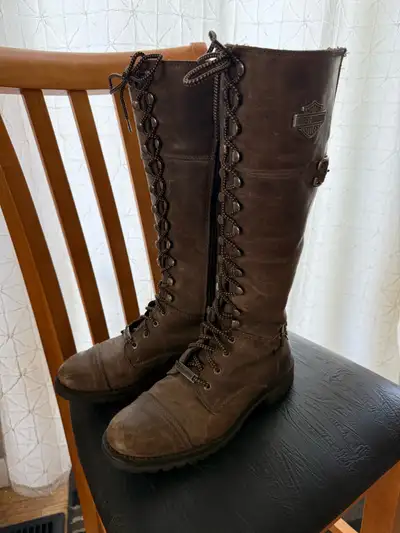 These are a pair of Harley Davidson brown leather lace-up knee-high boots in women's size 8.5. The b...