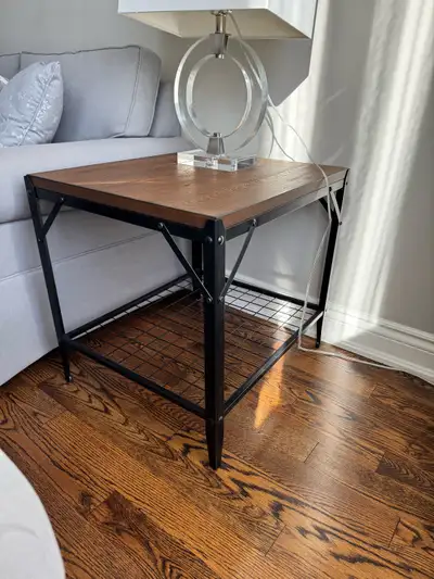 Selling a side table with a wood top and black metal frame. It has a shelf at the bottom for extra s...