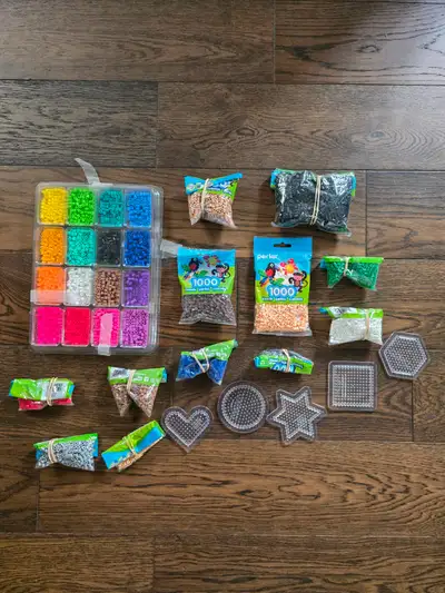 Set of Perler fusbile beads including bead tray set, additional bead bags of varying amounts, and va...