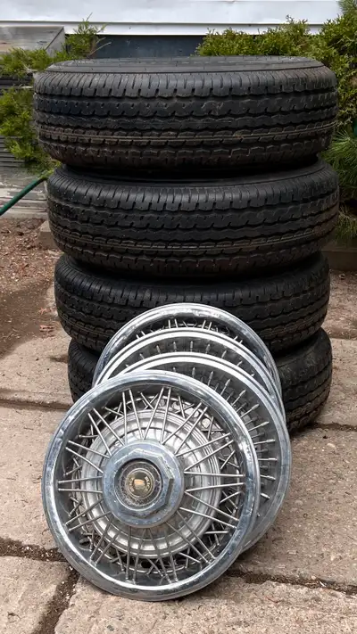 Four new trailer tires with rims and hub caps for sale. Size: ST-205/75R14