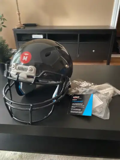 Medium sized football helmet Never used Comes with chinstrap and faceguard hardware pack