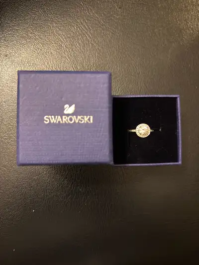 This is a used Swarovski crystal ring that adds a touch of sparkle to any outfit. The ring features...