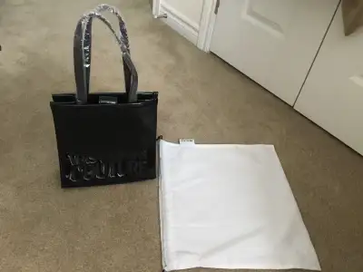 A mini tote bag crafted from a Versace Embossed Greek Pouch. This design features can be worn on the...