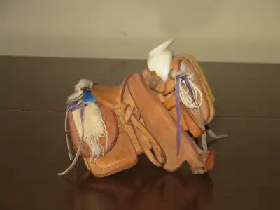 I have a vintage miniature handtooled leather Western saddle ~ it's only about 4 1/2" long complete...