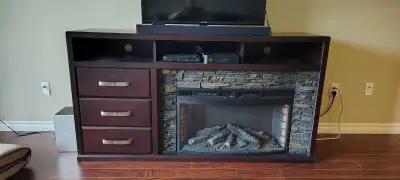 Entertainment unit with electric fireplace. Dark walnut finish with faux stone fireplace surround. A...