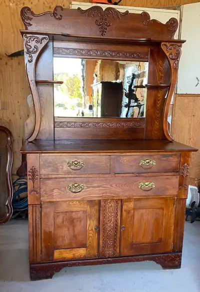 Meuble antique en bois massif avec un style victorien. Poignées et miroir d’origine en verre ondulé....