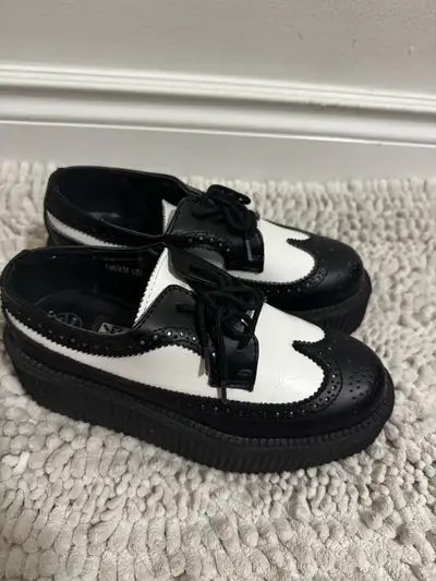 Step out in style with these used T.U.K. creepers, featuring a classic black and white design and a...