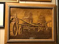 Wooden picture of grain elevators and a threshing machine.