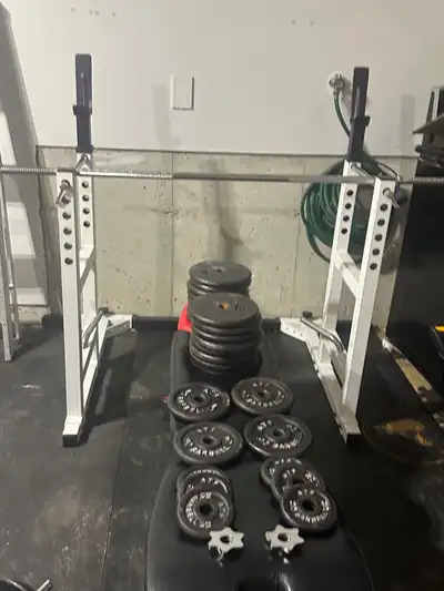 Full bench press/squat rack with barbell, dumbells, and weights