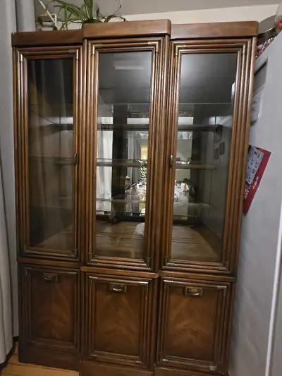 This is a vintage display cabinet featuring glass and wood construction, perfect for showcasing your...