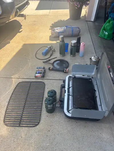 Camping stove with 2 full tanks and griddles, utensils,Solar shower, cast iron pan, flash ligh, torc...