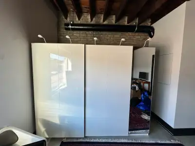 Pax wardrobe system in pristine condition. Sliding high gloss doors and full length mirror for the f...