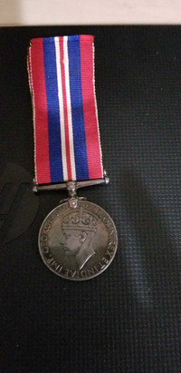 George VI war medal attached to red/white/blue stripe ribbon.Fro