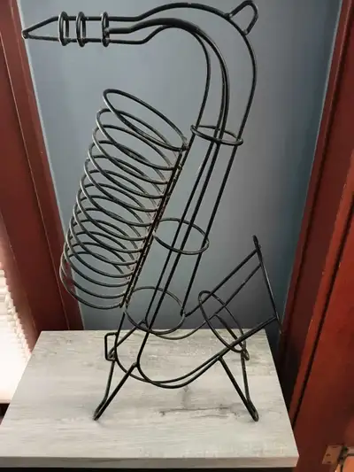 Add a jazzy touch to your space with this unique, used saxophone-shaped metal decor piece, perfect f...