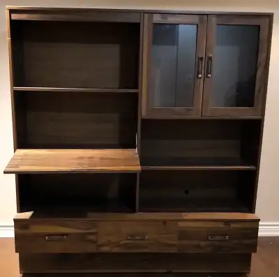 This sturdy wall unit offers ample storage with its integrated shelves, drawers, and glass door cabi...
