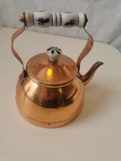 This vintage copper tea kettle with a blue and white Delft porcelain feature design is a charming ad...